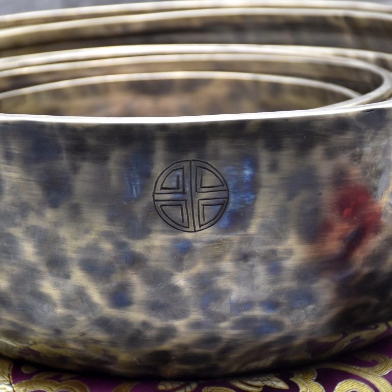 Set of textured metal bowls with a decorative symbol.